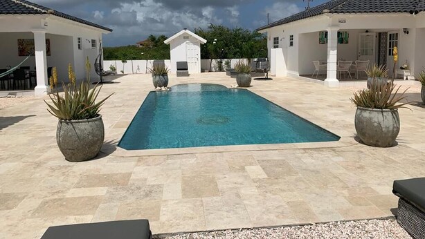 A swimming pool with a tiled deck, surrounded by potted plants and outdoor furniture. - Villa Buena, fantastic luxury villa with internet/ wifi (Hato)