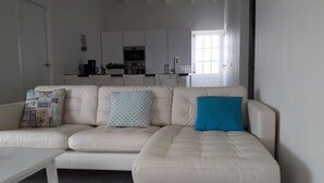 A living room with a beige sofa, a coffee table, and a kitchen in the background. - Villa Buena, fantastic luxury villa with internet/ wifi (Hato)