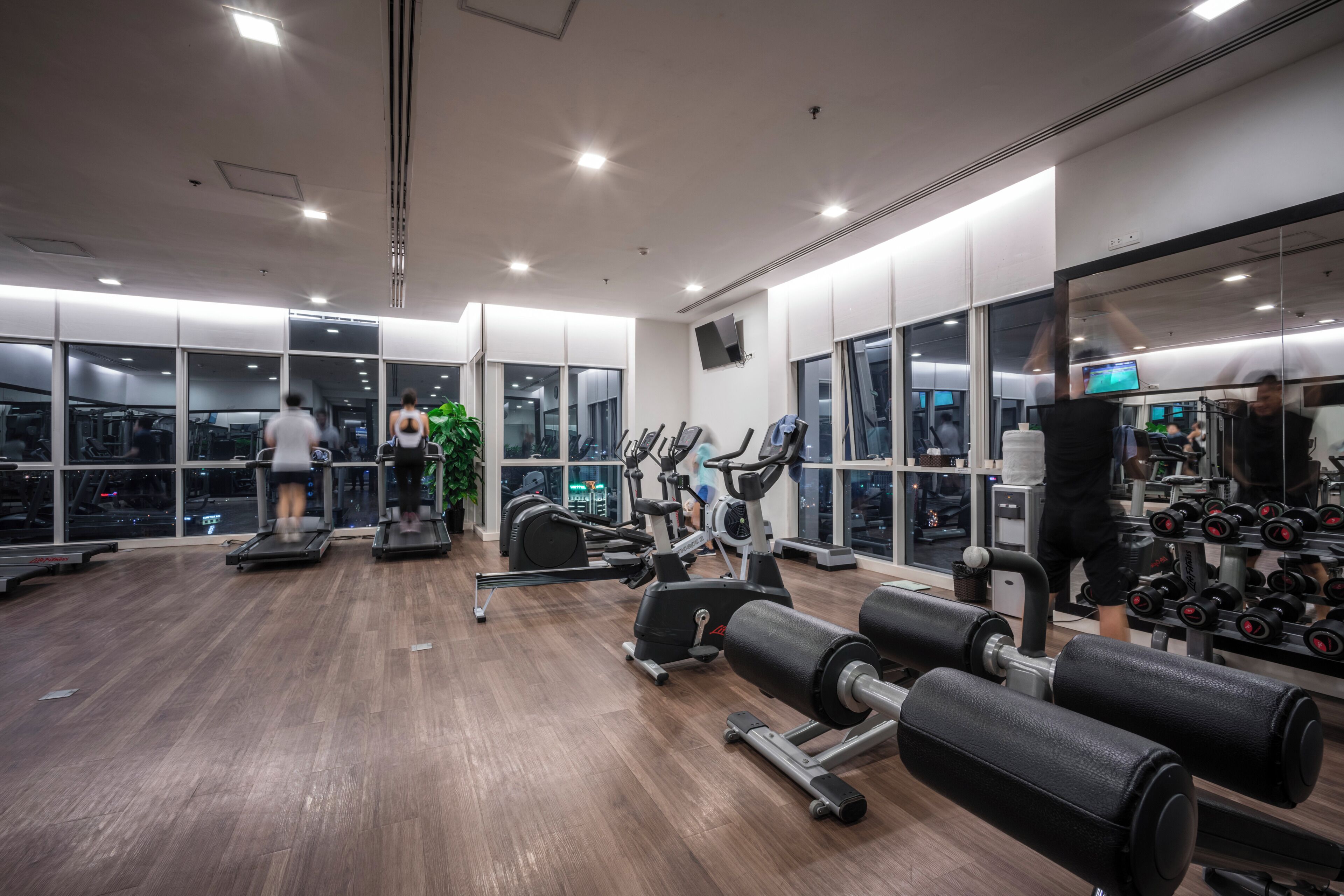 A gym with treadmills, elliptical machines, and free weights.