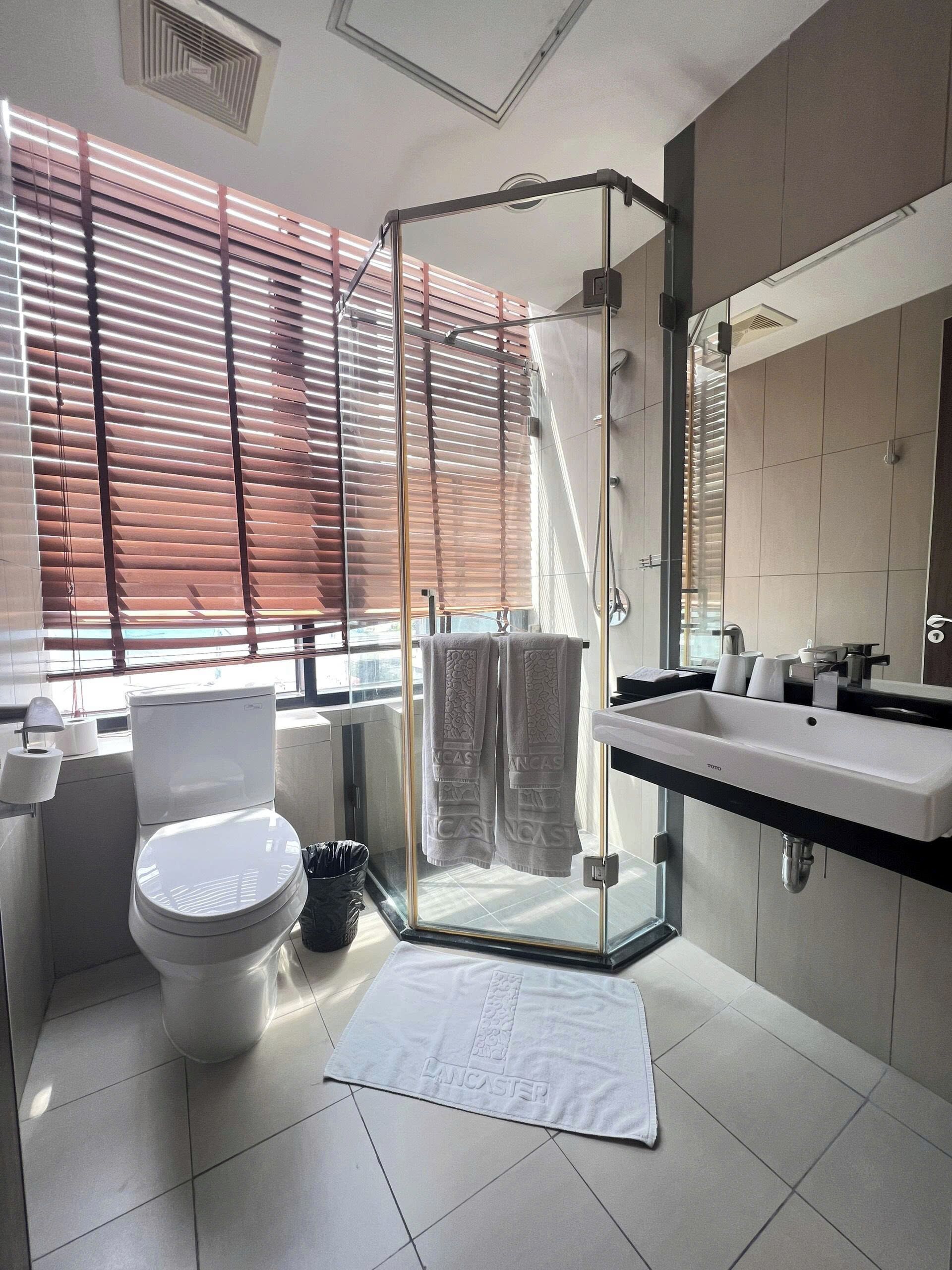 Une salle de bain moderne avec une douche à parois de verre, des toilettes et un lavabo avec un miroir.