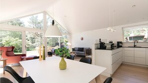 A modern kitchen with white cabinets, a black countertop, and a window overlooking a garden. - 3 bedroom nice home in Hasle (Hasle)