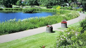 A park with a pond, walking path, and well-maintained greenery.