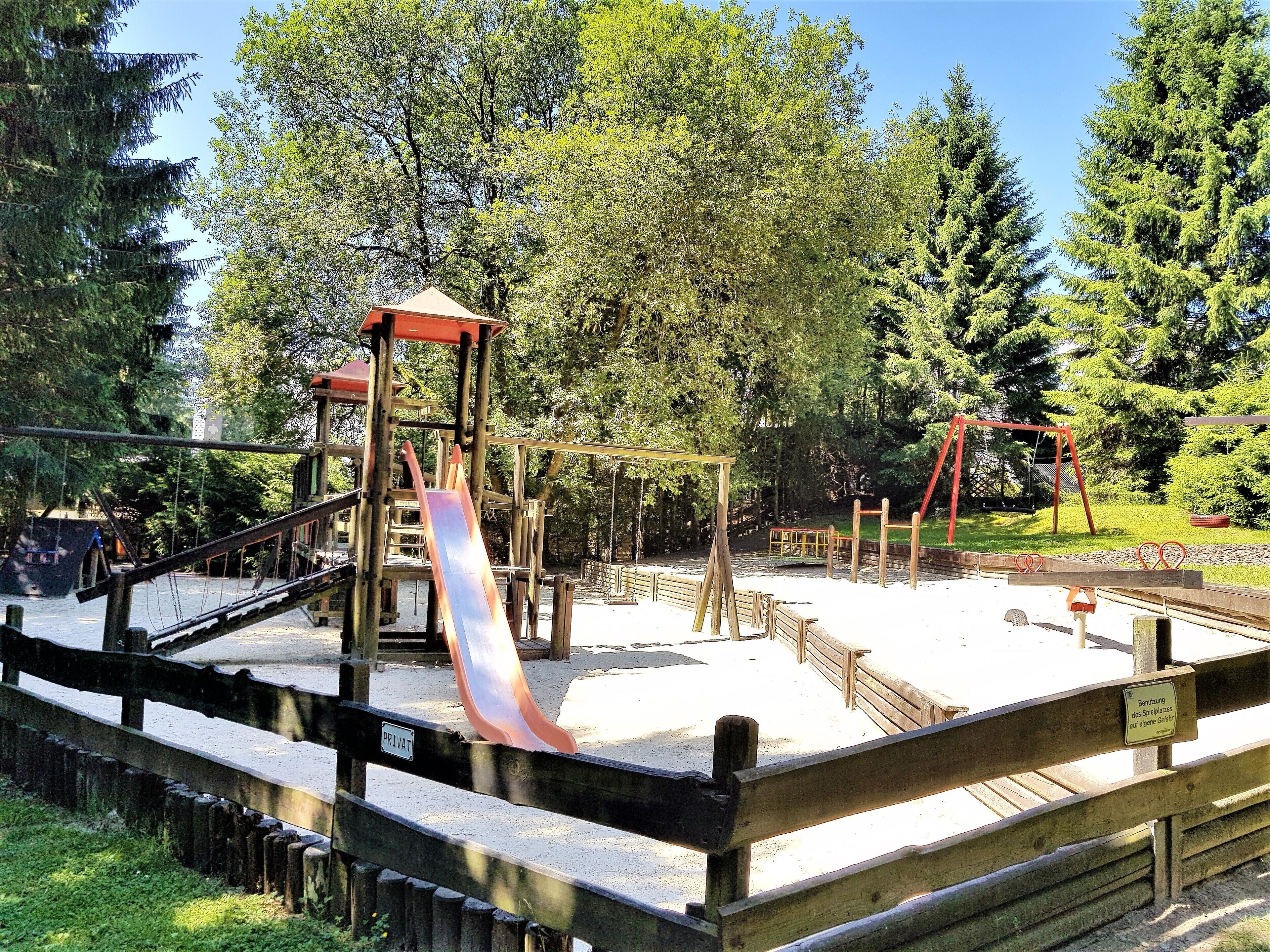A playground with a slide, swings, and a climbing structure.
