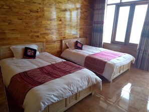 A room with two wooden beds, each with a white mattress and a red blanket. - Sau Meo Homestay (Sa Pa)