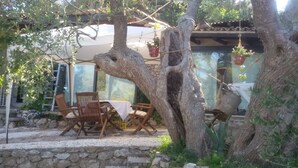 An outdoor seating area with stone steps, wooden chairs, and a table.