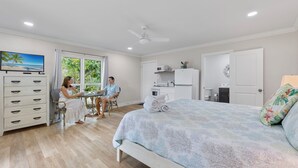 Ein Schlafzimmer mit einem Bett, einem Schreibtisch, einem Stuhl, einer Kommode und einem Fernseher.