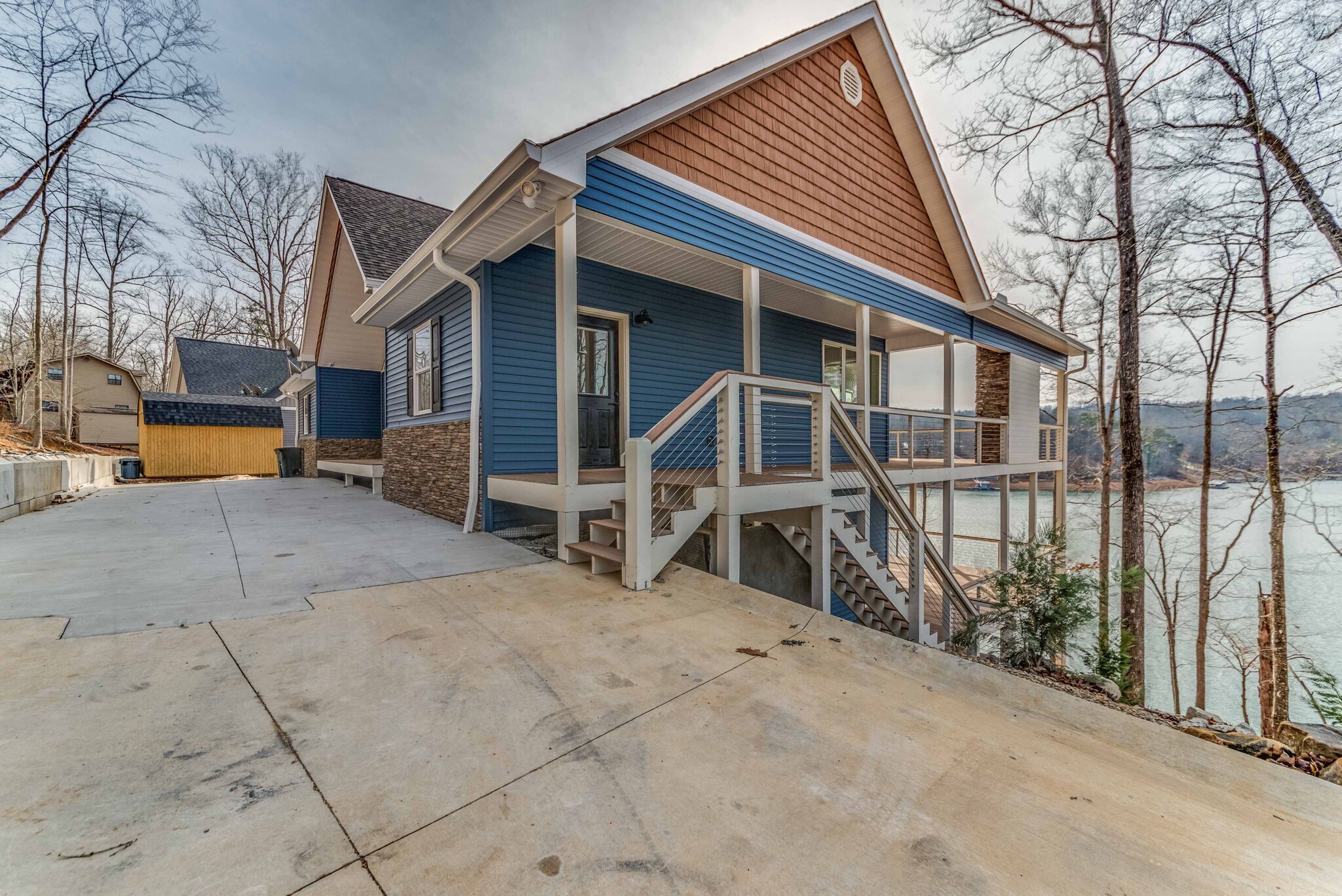 A two-story house with a covered porch and a staircase leading to the upper level.