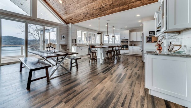 Una cocina amplia con suelo de madera, ventanas grandes y techo alto.