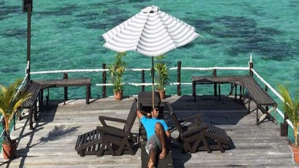 A wooden deck with lounge chairs and an umbrella, overlooking turquoise waters and distant mountains. - Lato Lato Resort (Semporna)