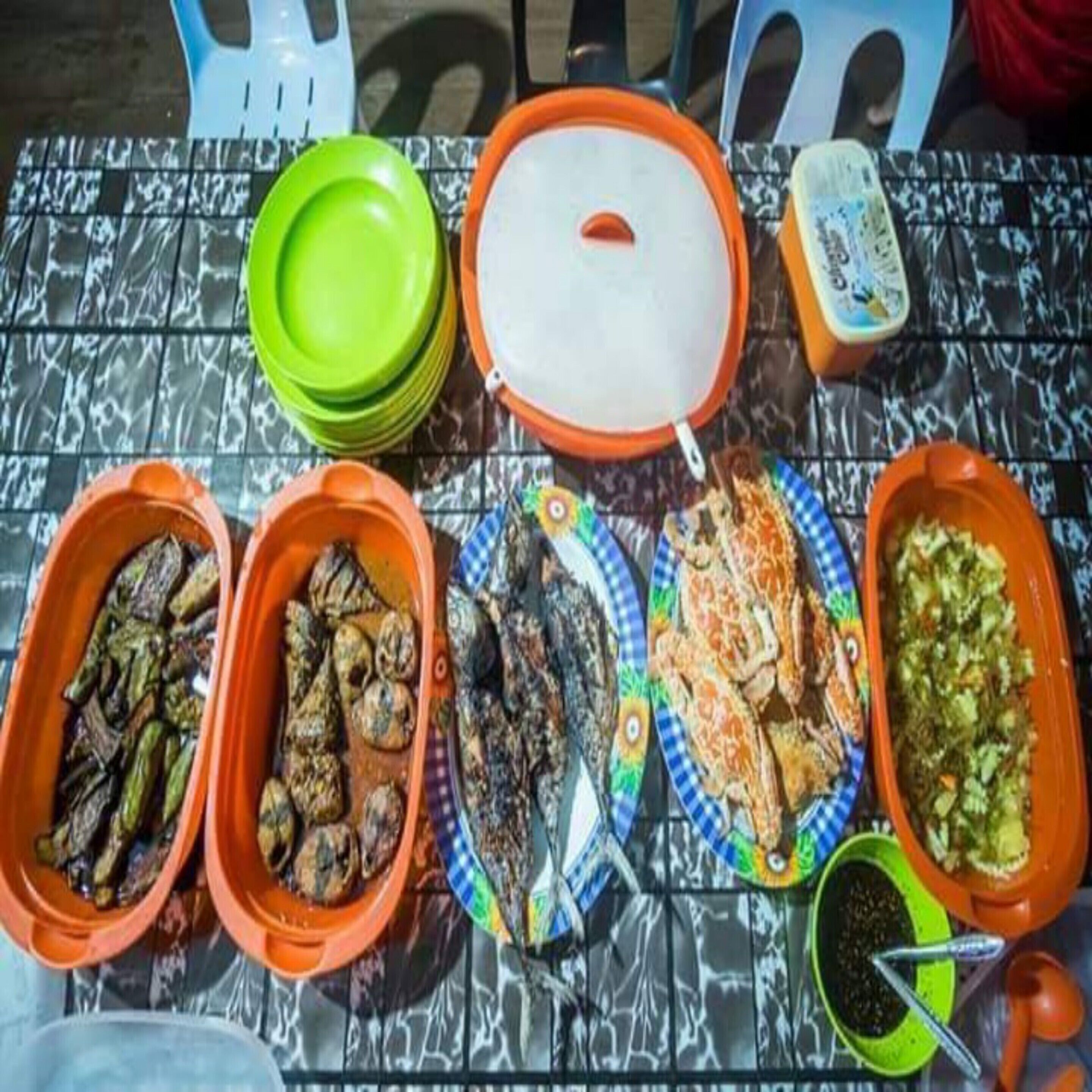 Una mesa con diferentes platos y recipientes, probablemente para una comida o un bufé.