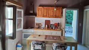 Une cuisine avec des meubles de rangement en bois, une cuisinière, un évier et une fenêtre.
