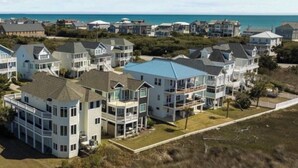 A coastal residential area with multi-story houses, some with balconies, and a clear view of the ocean. - The Big Dream Getaway 💙Private Heated Pool Sleeps 13 (Atlantic Beach)