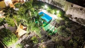 An aerial view of a courtyard with a swimming pool, surrounded by trees and greenery. - GARDEN OF THE VESUVIUS (Terzigno)