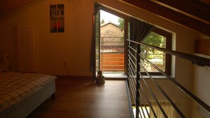A bedroom with a bed, a window, and a view of the outside. - An oasis of peace: the Honey House (PINEROLO)