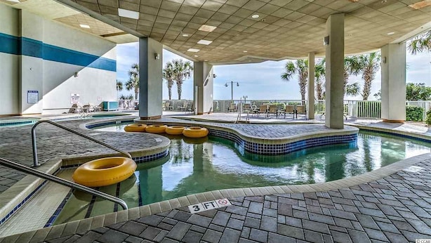 Área de piscina interna com chão ladrilhado, boias amarelas e indicador de profundidade de 3 pés.