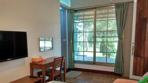A room with a bed, a desk with a chair, a television, and a window with curtains. - Clove House (Hengchun)
