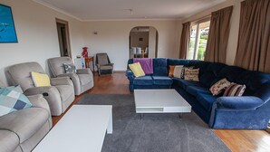 A living room with grey and blue sofas, a white coffee table, and a grey rug.