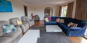 A living room with grey and blue sofas, a white coffee table, and a grey rug.