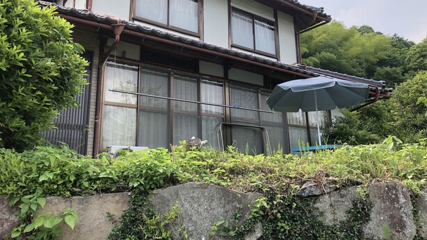 A traditional Japanese-style building with multiple windows, a tiled roof, and an umbrella. - Hidejiro (Fukuchiyama)