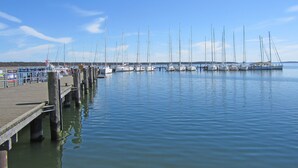 A marina with multiple sailboats docked along a wooden pier. - Reusenhaus South in Breege (Breege)