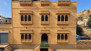 A multi-story building with a symmetrical facade, featuring ornate window frames and decorative elements. - Hotel Swan Haveli (Jaisalmer)