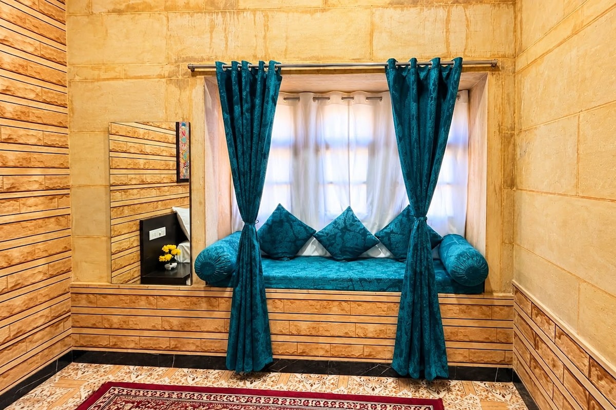 A room with a built-in bench, teal curtains, and a patterned rug.