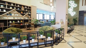 A modern library with bookshelves, seating areas, and decorative lighting. - Kailan Hotel (Toucheng)