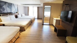 A hotel room with three beds, a TV, and a wooden floor. - Kailan Hotel (Toucheng)