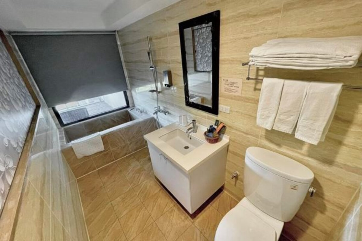 A modern bathroom with a bathtub, sink, and toilet.
