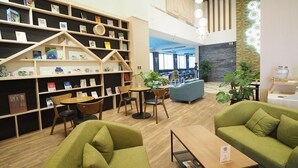 A modern library with bookshelves, seating areas, and a coffee station. - Kailan Hotel (Toucheng)