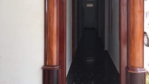 A wooden entrance with a black marble floor leading into a hallway.