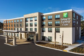 A Holiday Inn Express building with a modern design, featuring a covered entrance and a landscaped area with small trees. - Holiday Inn Express & Suites Kingsland I-95-Naval Base Area by IHG (Kingsland)