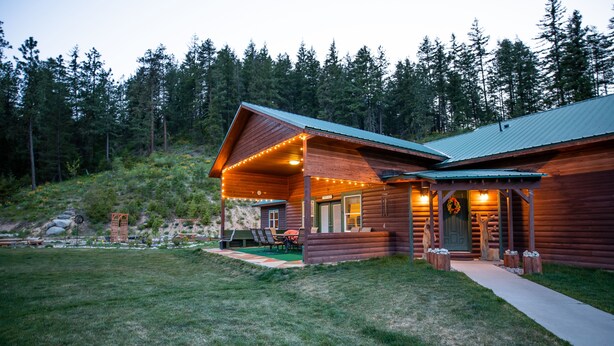 A wooden cabin with a covered patio and a visible door. - Spacious Private Lodge with Mountain Views (Leavenworth)