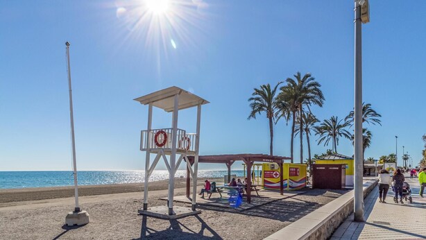 A beach with a lifeguard tower, palm trees, and a clear sky. - Amazing home in Periana (Periana)