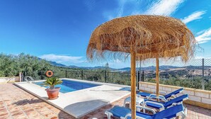 A pool area with a view of mountains, a lifebuoy, and lounge chairs. - Amazing home in Periana (Periana)