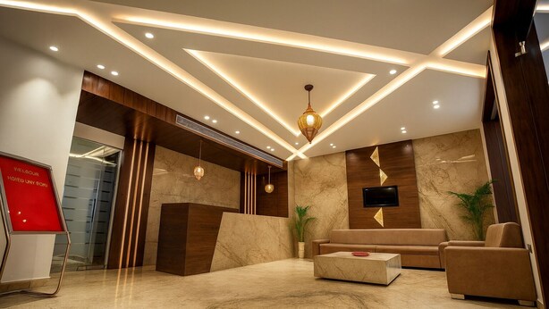 A modern lobby with a reception desk, seating area, and a TV mounted on the wall. - HOTEL TEN SQUARE - 5 Minutes from The Taj Mahal (Agra)