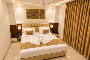 A hotel room with a large bed, a ceiling fan, a wall-mounted artwork, and a curtain. - HOTEL TEN SQUARE - 5 Minutes from The Taj Mahal (Agra)
