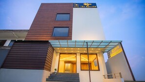 A modern hotel with a glass entrance, a wooden facade, and a sign reading "TEN SQUARE". - HOTEL TEN SQUARE - 5 Minutes from The Taj Mahal (Agra)