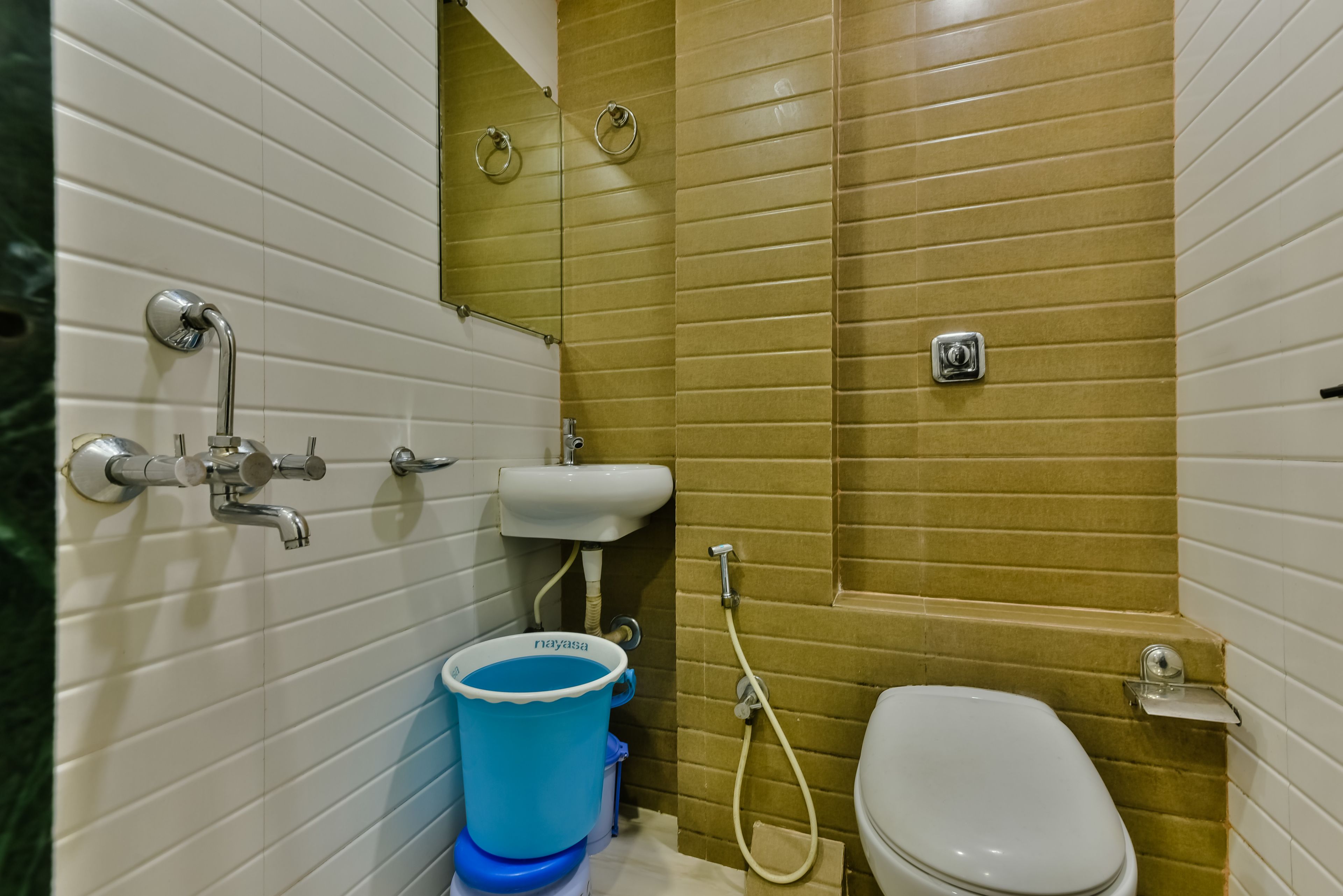Et lille badeværelse med toilet, håndvask og brusebad.