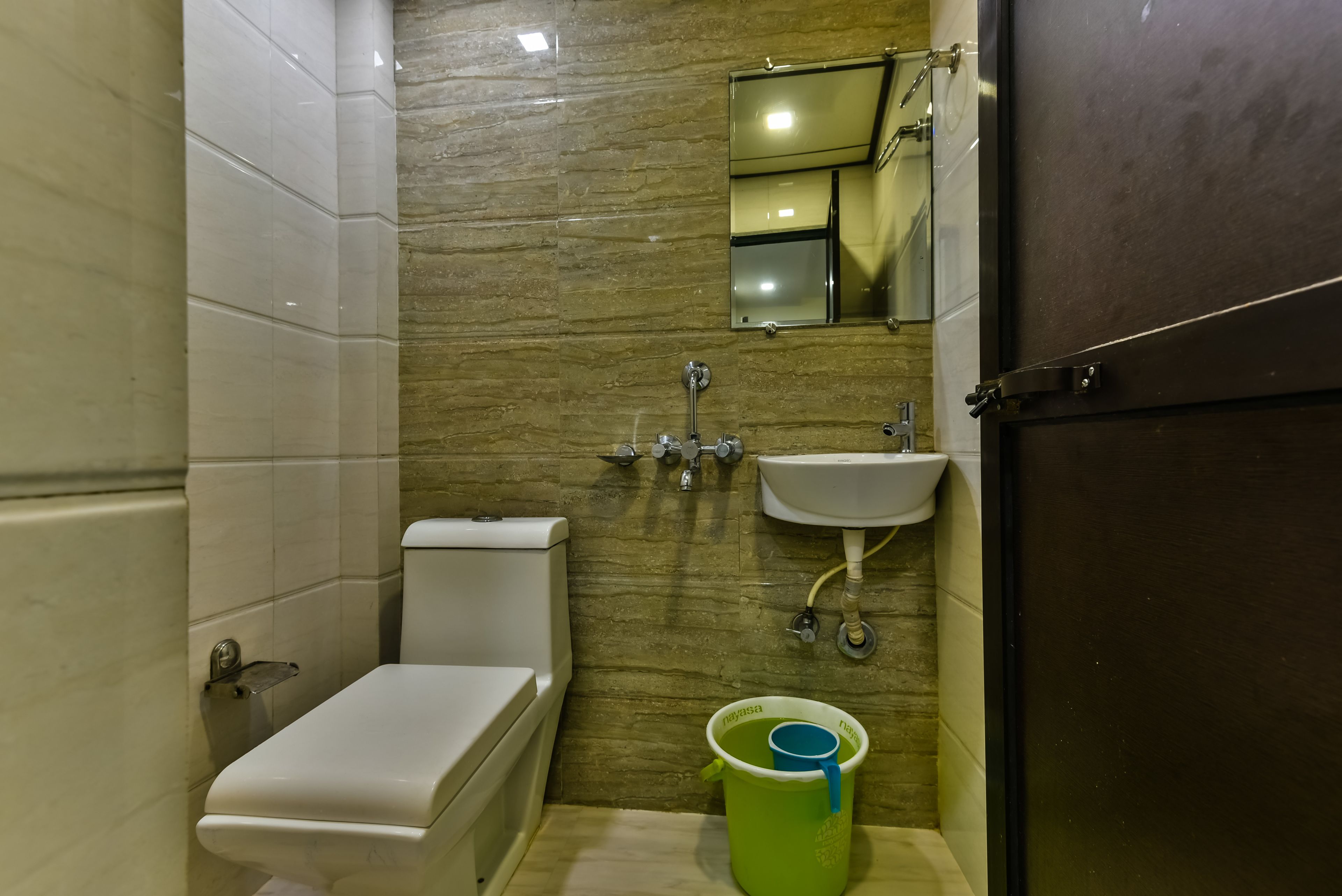 A compact bathroom with a toilet, sink, and mirror.