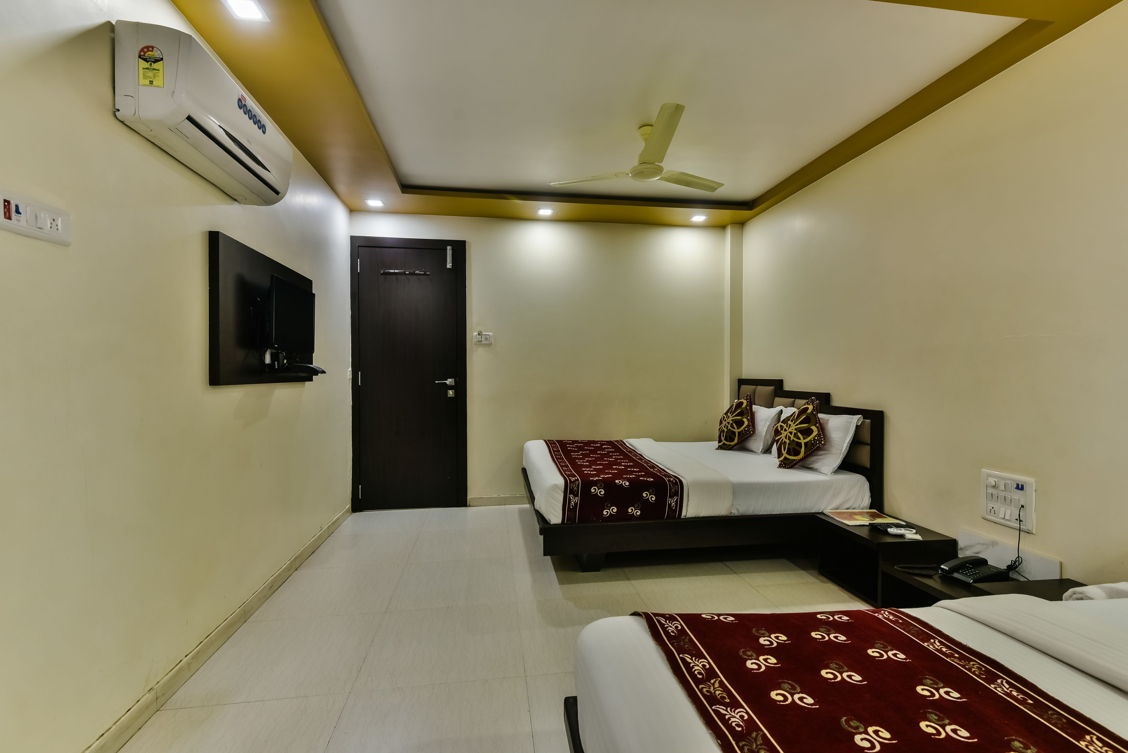 A hotel room with a bed, bedside table, and a ceiling fan.