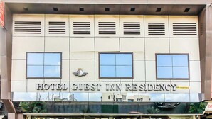 Un bâtiment portant l’enseigne « HÔTEL, CHAMBRES D’INVITÉS, RÉSIDENCE ».