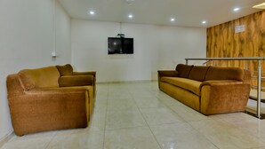Une pièce spacieuse avec deux canapés, un téléviseur à écran plat fixé au mur et un mur décoratif en bois.
