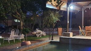 An outdoor pool area with seating and a pergola. - Callies Game Lodge Safaris (Tsumeb)