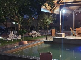 An outdoor pool area with seating and a pergola.