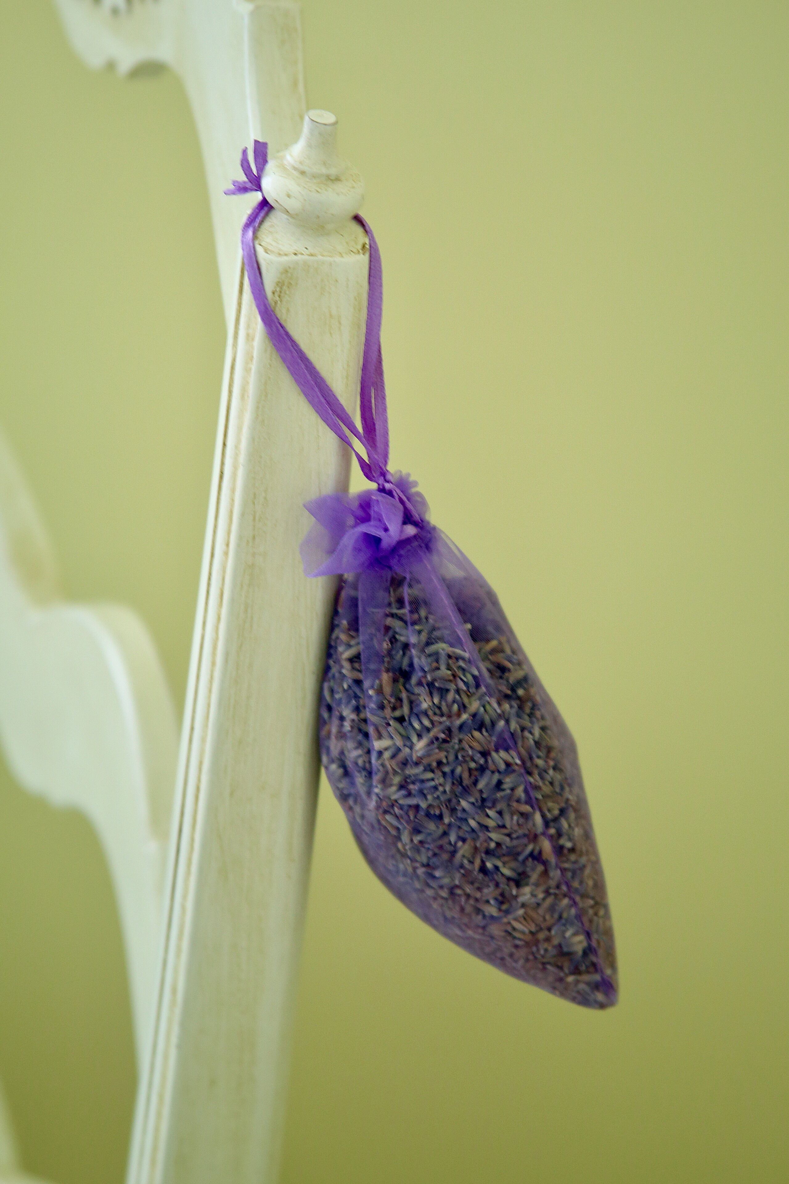 A hanging bag of dried lavender tied with a purple ribbon.