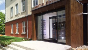 Ein Gebäude mit moderner Fassade, großen Glasfenstern und einem Holzeingang.