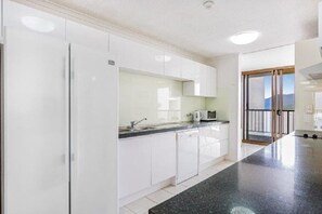 Enjoy a meal with a view from this kitchen, which opens to a balcony overlooking the mountains.