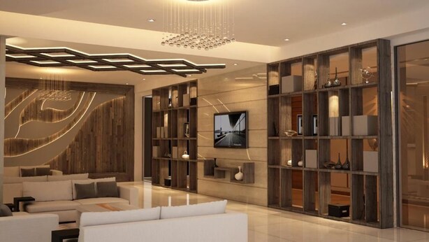 Una sala de estar moderna con un sofá modular, un televisor de pantalla plana y estanterías empotradas decoradas con objetos ornamentales.