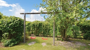 Un giardino con altalena e un pergolato.